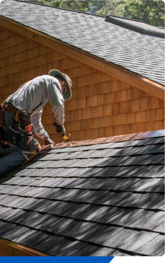 Roofer repairing metal flashing on asphalt roof