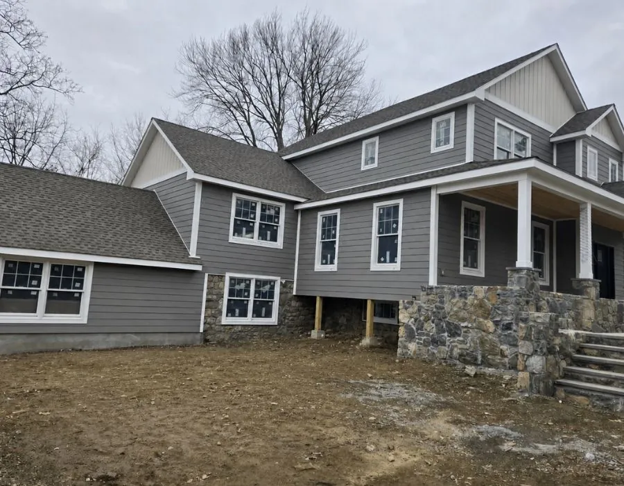Charcoal grey siding on stone foundation and roof replacement